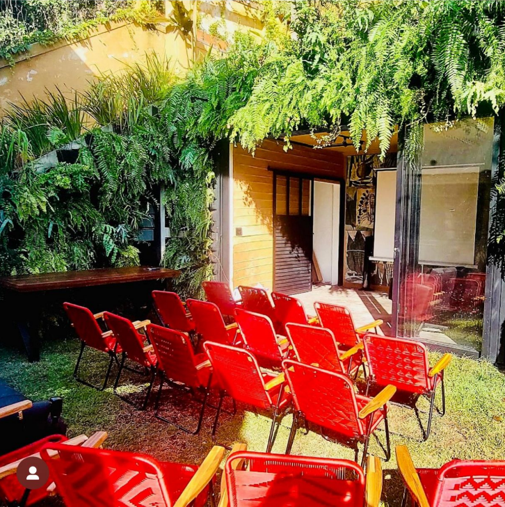 Cadeiras vermelhas no jardim para a roda de conversa